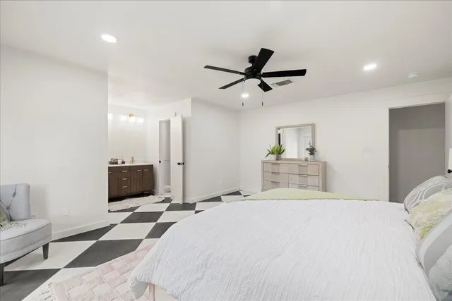 a bedroom with a large bed and a chandelier