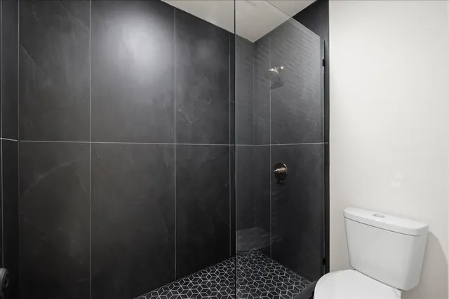 a bathroom with a toilet and a shower