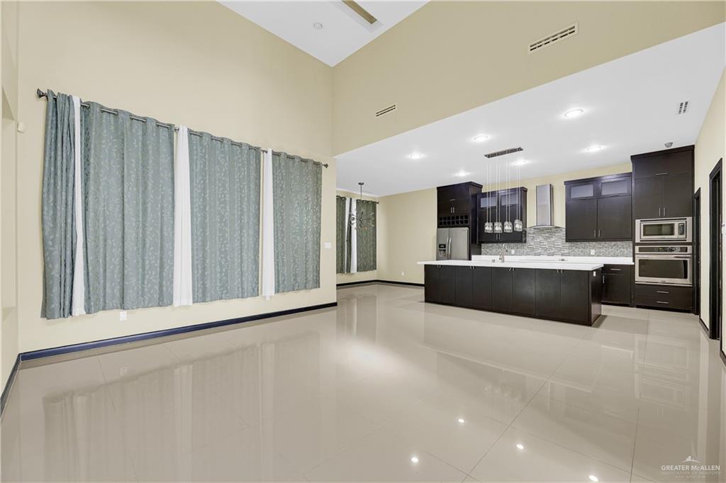 1720 Rice Avenue McAllen, TX 78504 - Photo 5 of 19 a large white kitchen with a refrigerator a counter top space and cabinets