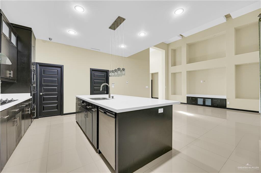 1720 Rice Avenue McAllen, TX 78504 - Photo 6 of 19 a kitchen with stainless steel appliances granite countertop a sink and a stove top oven with wooden floor