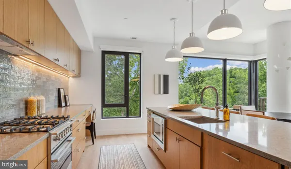 a kitchen with stainless steel appliances granite countertop a sink a stove and a wooden floors