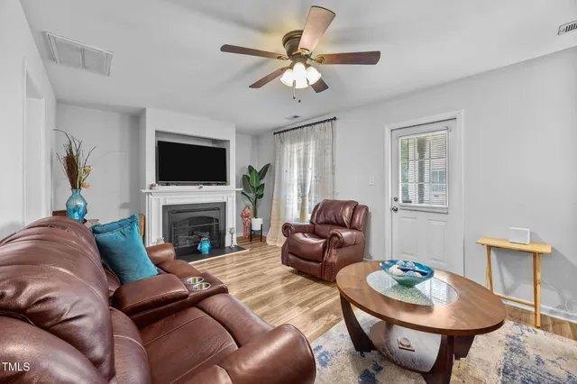 a living room with furniture a fireplace and a flat screen tv