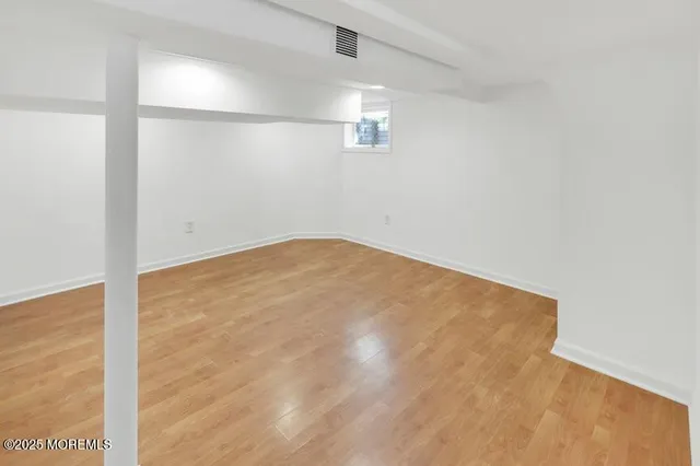 an empty room with ceiling fan and window