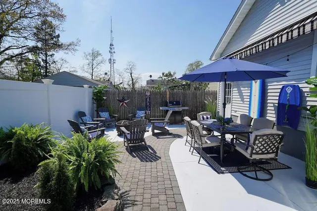 a view of a patio with table and chairs under an umbrella