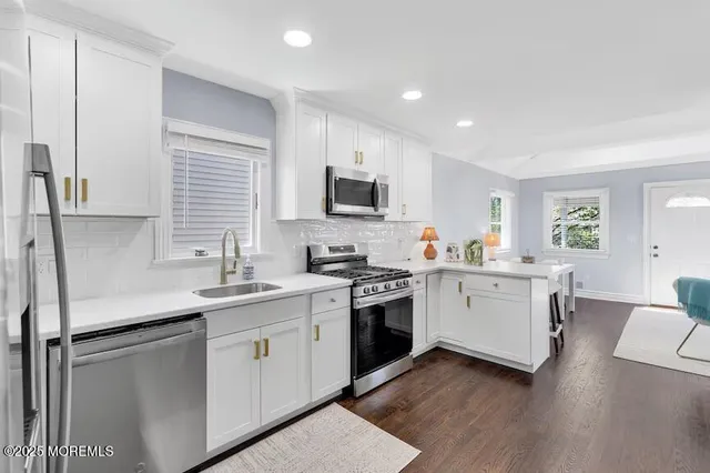 a kitchen with sink stove and white cabinets