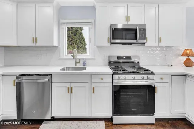 a kitchen with cabinets stainless steel appliances and sink