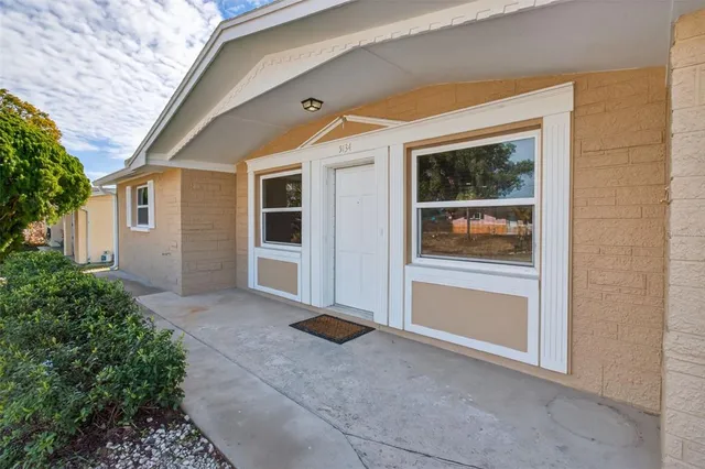 a view of house with backyard and glass windows