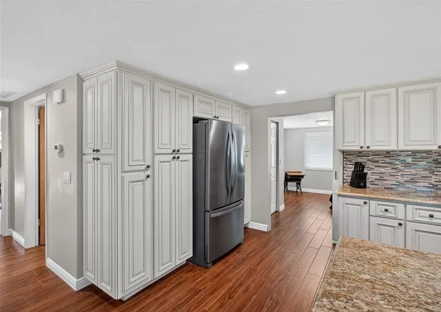 a kitchen with stainless steel appliances granite countertop a refrigerator and a stove top oven