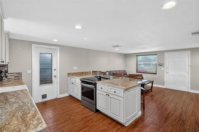 a kitchen with a stove and a wooden floors