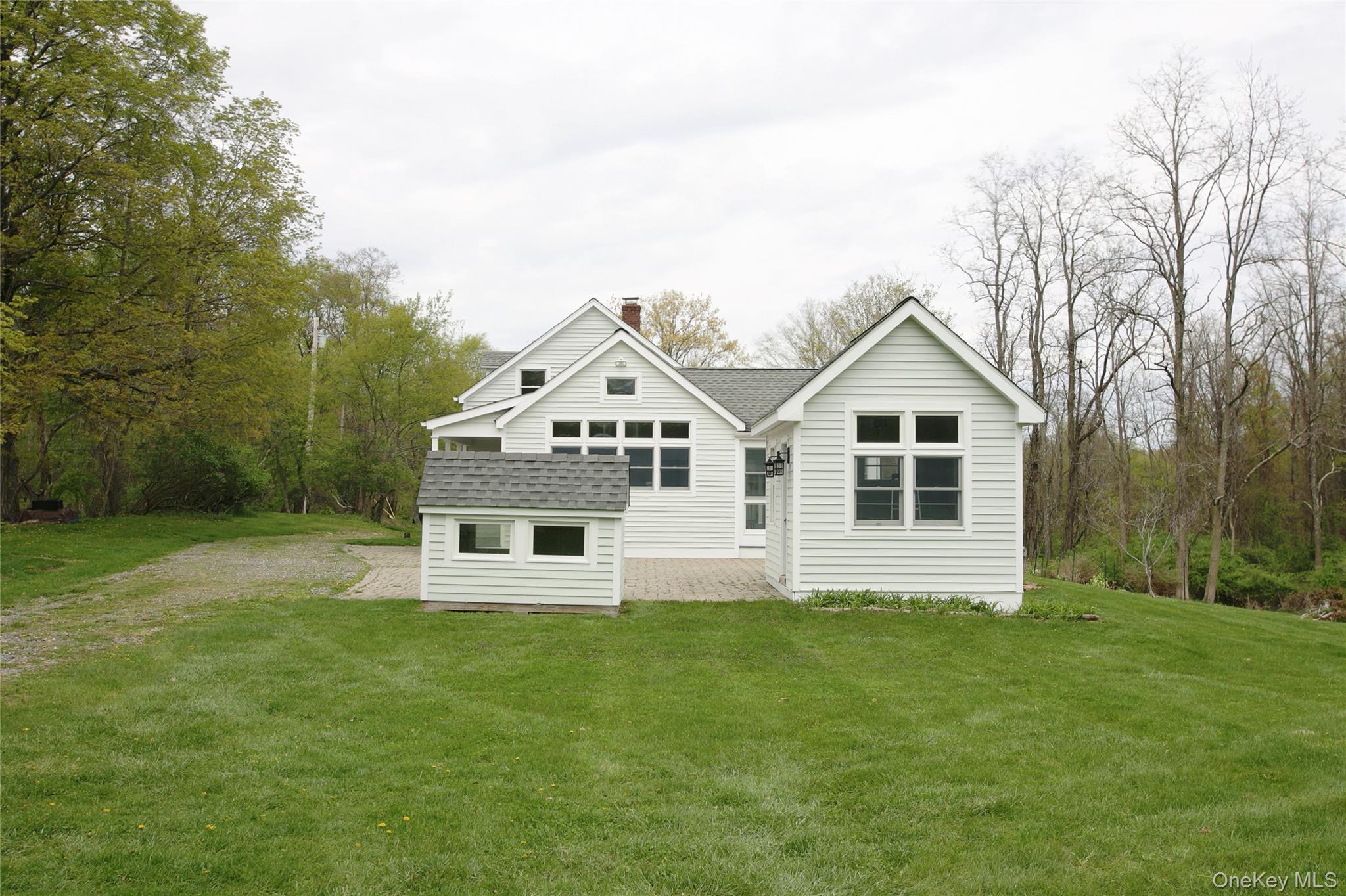 292 Mountain View Road Rhinebeck, NY 12572 - Photo 9 of 30 a white house with a small yard and large trees