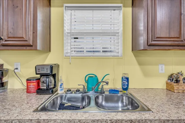 a kitchen with granite countertop a sink a stove and cabinets