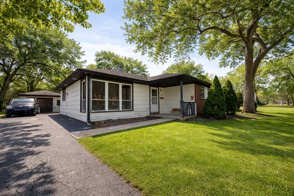 a front view of a house with a yard and trees