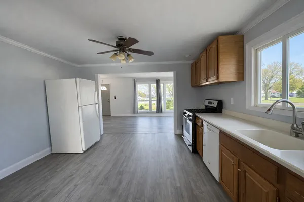 a kitchen with refrigerator a stove a sink and a window