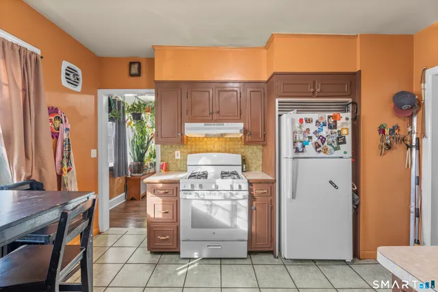a kitchen with a stove a refrigerator and a table
