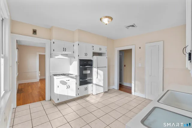a kitchen with granite countertop a refrigerator and a sink