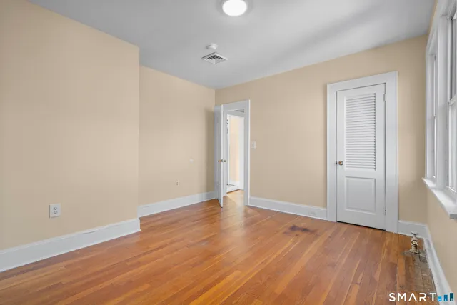 a view of an empty room with wooden floor