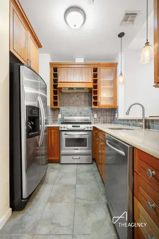 a kitchen with stainless steel appliances granite countertop a sink stove and refrigerator