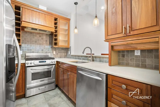 a kitchen with stainless steel appliances granite countertop a sink and a stove