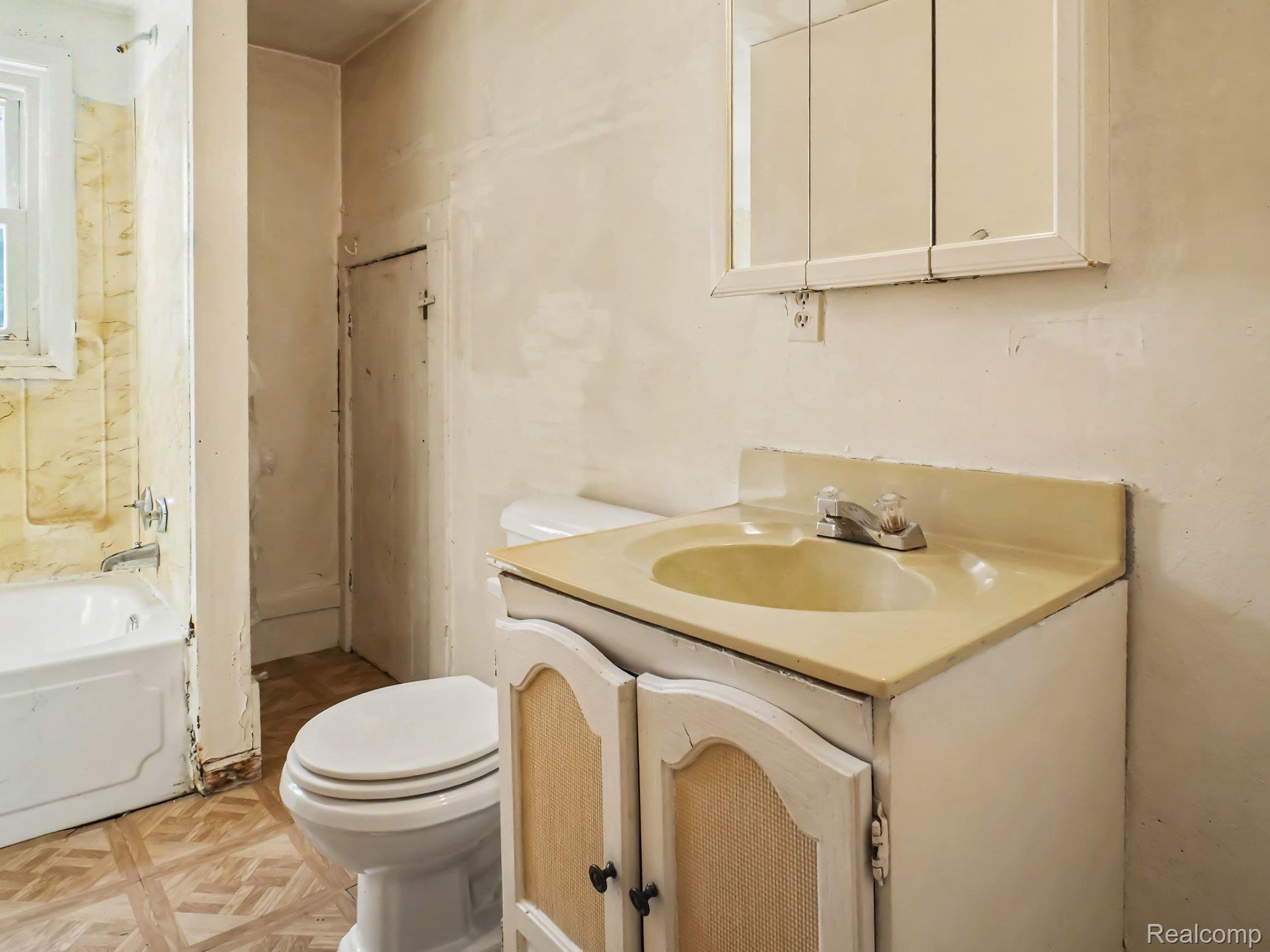 12073 Lahring Road Byron, MI 48418 - Photo 18 of 36 Bathroom featuring a wood-finish vanity with dual cabinet doors, integrated sink with countertop surface, and ceramic tile flooring