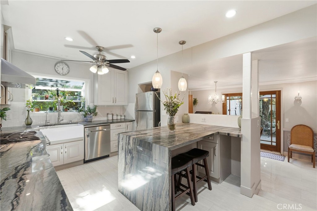 4963 Haskell Avenue Encino, CA 91436 - Photo 11 of 45 a kitchen with stainless steel appliances kitchen island granite countertop a table chairs sink and cabinets