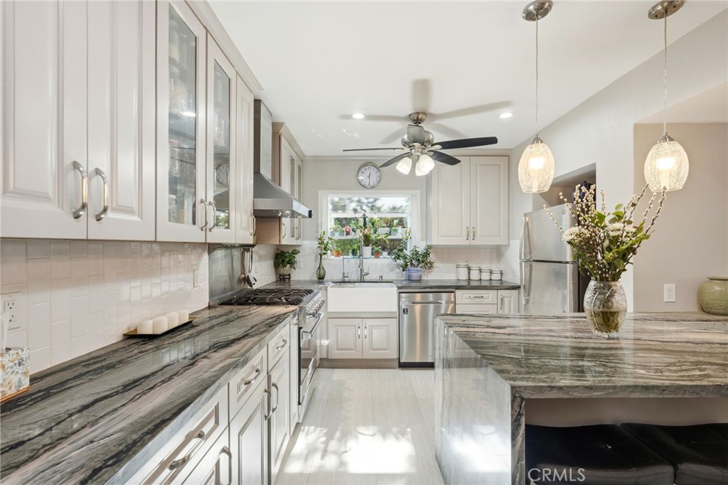 4963 Haskell Avenue Encino, CA 91436 - Photo 12 of 45 a kitchen with stainless steel appliances kitchen island granite countertop a stove a sink and a white cabinets