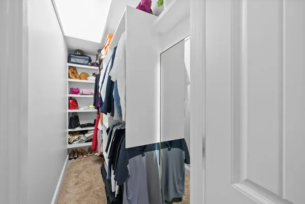 a view of walk in closet with clothes