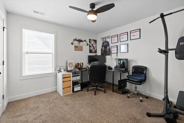 a view of a workspace with furniture and a window
