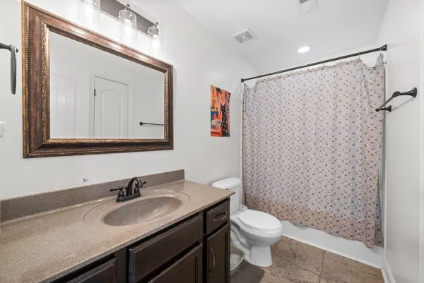a bathroom with a granite countertop sink toilet and shower