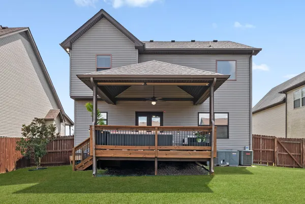 a front view of house with deck and yard