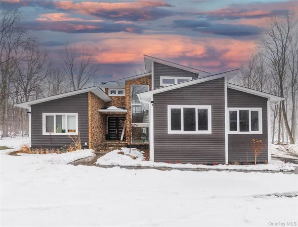 a front view of a house with a yard covered in snow