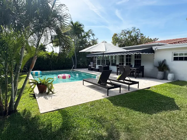 a view of a patio with table and chairs under an umbrella