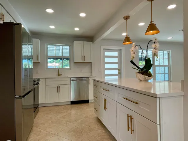 a kitchen with white cabinets and refrigerator