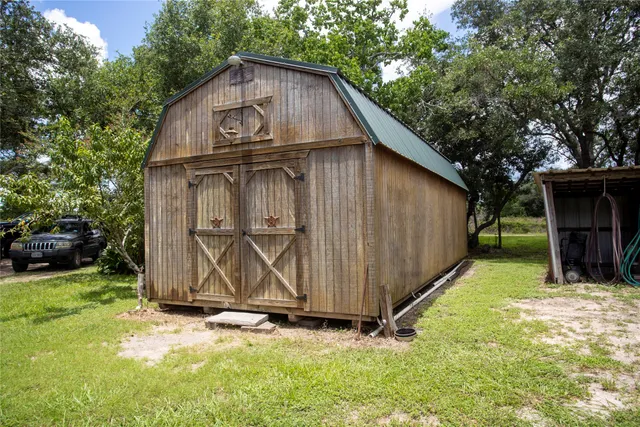 a view of a tiny house with yard and a tree
