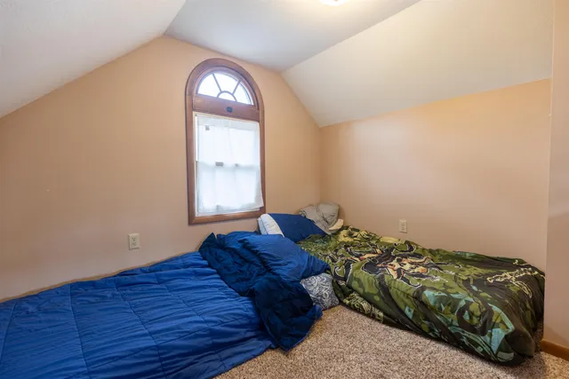 a bed sitting in a bedroom next to a window