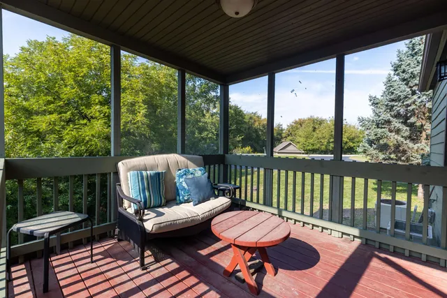 a view of a balcony with chair and wooden floor