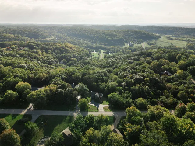 an aerial view of house with yard and mountain view in back