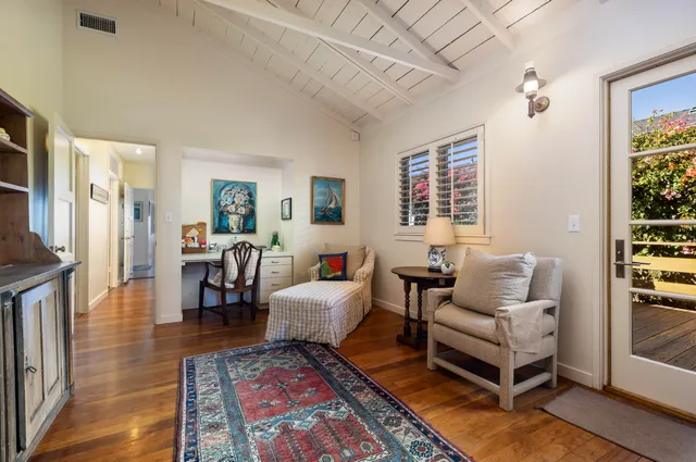 a bed sitting in a spacious bedroom next to a window
