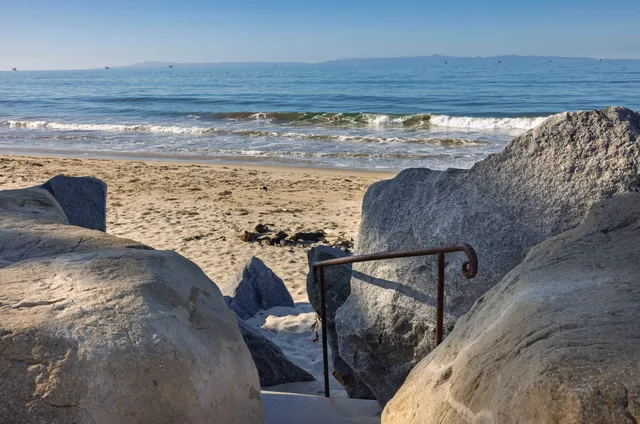 a front view of a house with a yard and potted plants