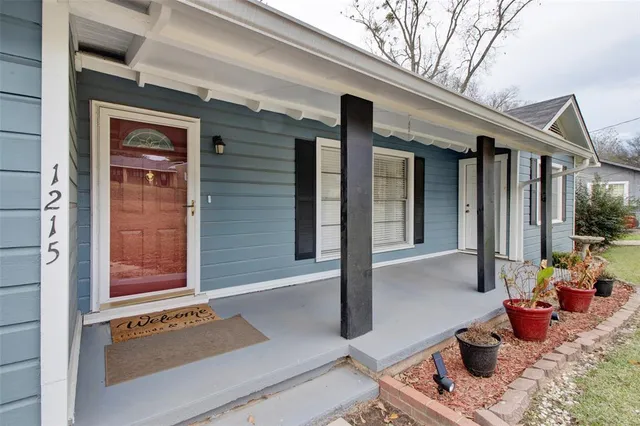a view of porch with a table and chairs and potted plants