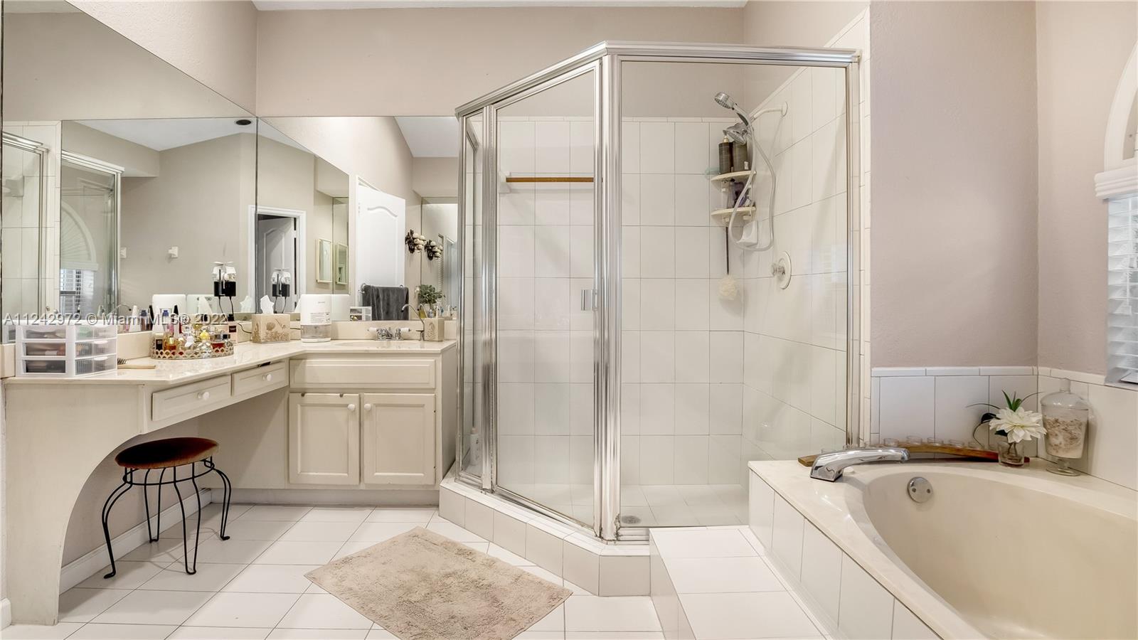 20310 Southwest 48th Street Southwest Ranches, FL 33332 - Photo 12 of 25 a bathroom with a tub a sink a mirror and a shower