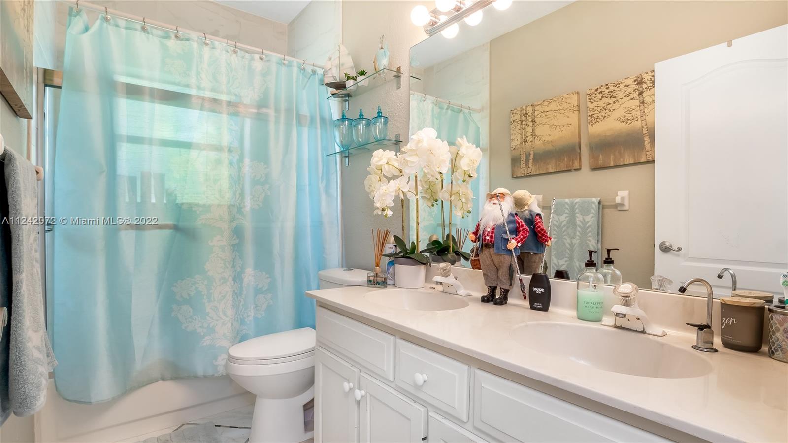 20310 Southwest 48th Street Southwest Ranches, FL 33332 - Photo 16 of 25 a bathroom with a sink a toilet and shower curtain
