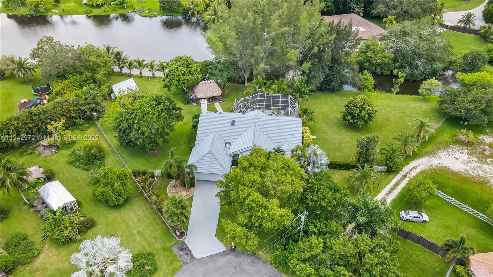 20310 Southwest 48th Street Southwest Ranches, FL 33332 - Photo 2 of 25 an aerial view of a house with a yard and lake view