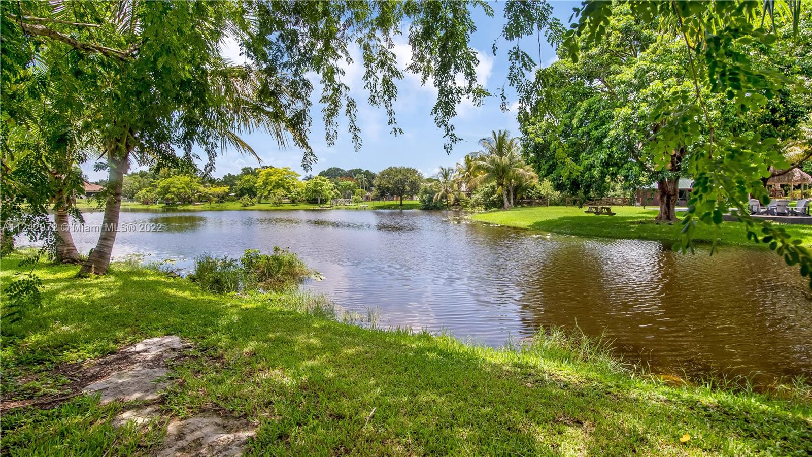 20310 Southwest 48th Street Southwest Ranches, FL 33332 - Photo 24 of 25 a view of a lake with a house in the background