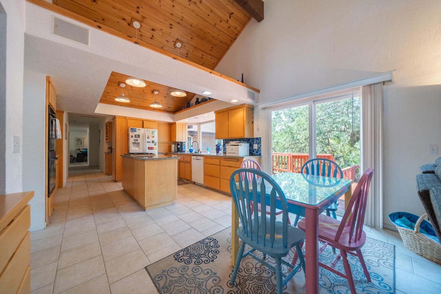 8846 Goldstone Lane Redding, CA 96001 - Photo 16 of 64 a view of a dining room and livingroom with furniture wooden floor a rug a fireplace