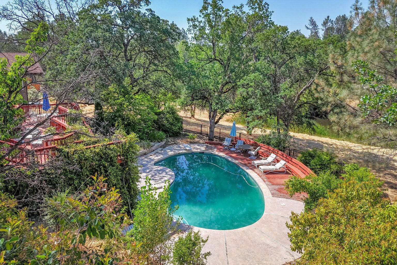 8846 Goldstone Lane Redding, CA 96001 - Photo 62 of 64 an aerial view of a swimming pool with lawn chairs and large trees