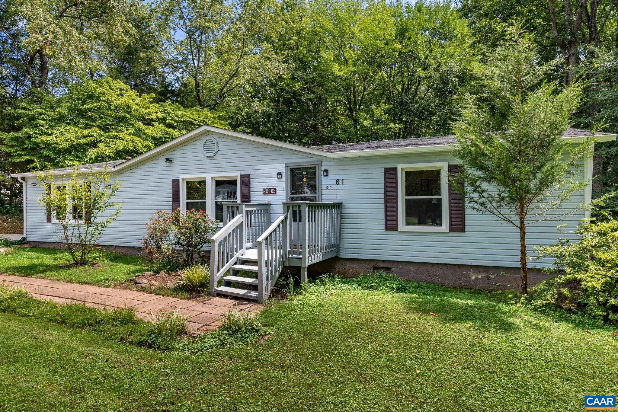 61 Snapdragon Road Ruckersville, VA 22968 - Photo 36 of 47 Inviting single-story home featuring light siding, contrasting dark shutters, and a cozy wooden front porch. Nestled on a lush green lawn with mature shade trees, it offers classic suburban charm, peace, and timeless curb appeal!