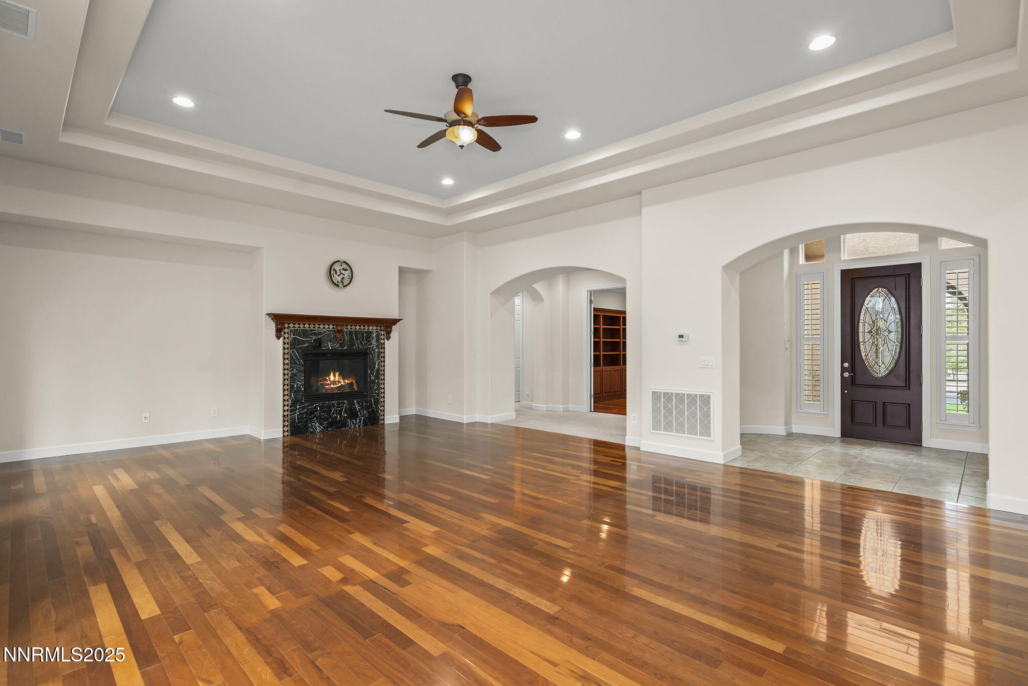 6225 Elk Ivory Drive Reno, NV 89511 - Photo 6 of 44 a view of an empty room with wooden floor and a ceiling fan