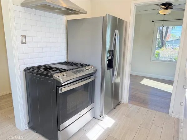 a kitchen with stainless steel appliances granite countertop a refrigerator and a stove