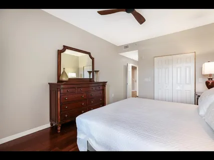 a bedroom with a bed and a lamp on dresser
