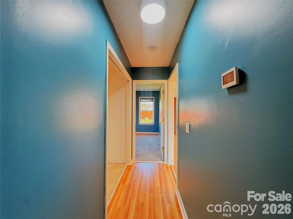 7456 Courtney Pines Road Wilmington, NC 28411 - Photo 14 of 16 a view of a hallway with wooden floor and closet